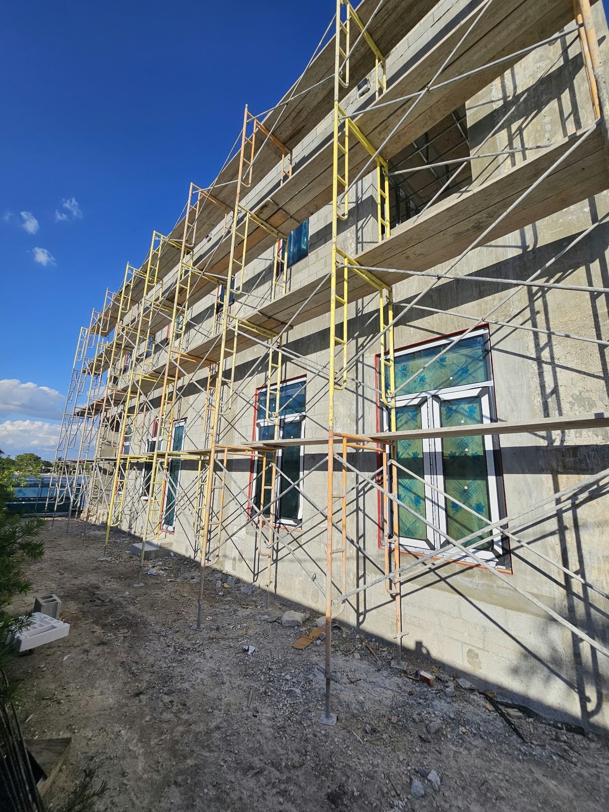 Instalación de ventanas contra impacto en edificio, con andamios